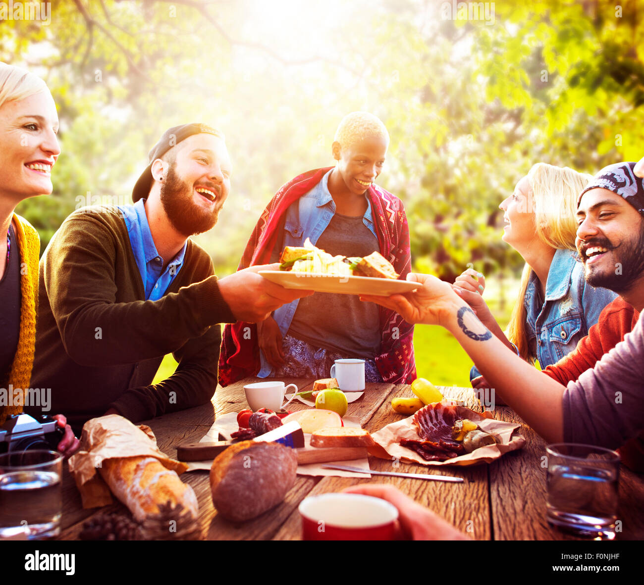 Amigo celebrar fiesta alegre estilo picnic concepto potable Foto de stock