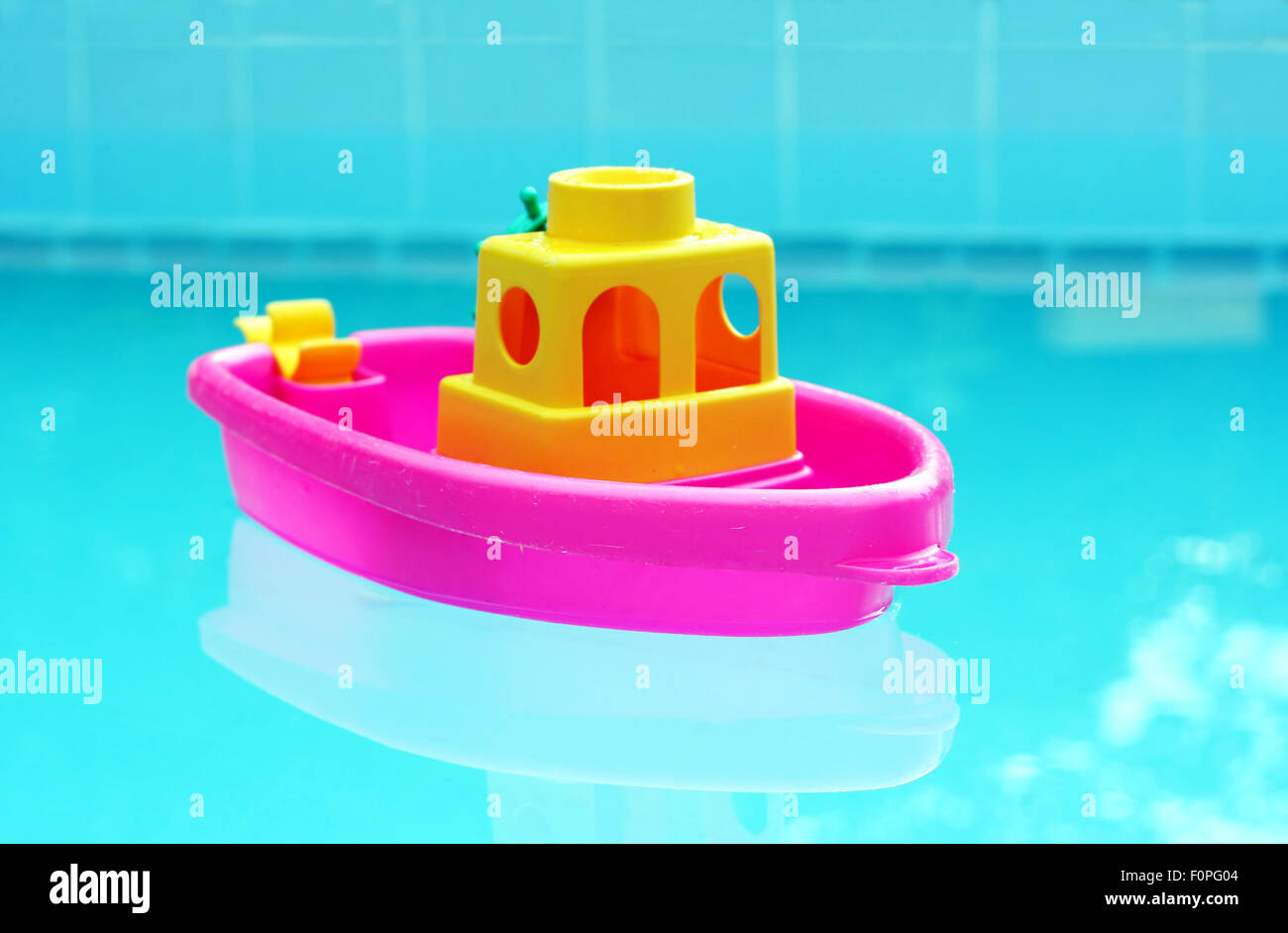 Juguete pequeño bote de plástico flotando en una piscina Foto de stock