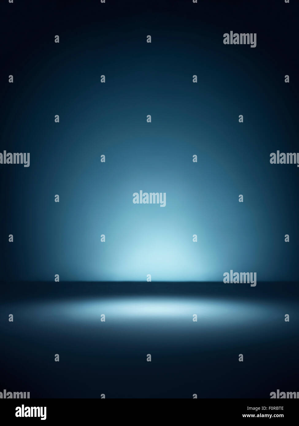 Foto de un simple fondo azul iluminado con iluminación puntual de vignette estilo con copia espacio para el diseñador. Foto de stock