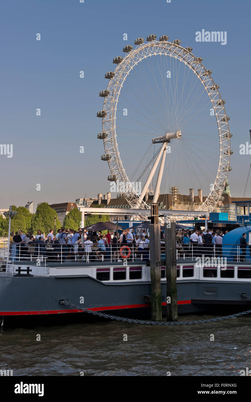 Las personas a bordo del Tattershall Castle, un bar flotante sobre el río  Támesis con el London Eye de fondo Fotografía de stock - Alamy