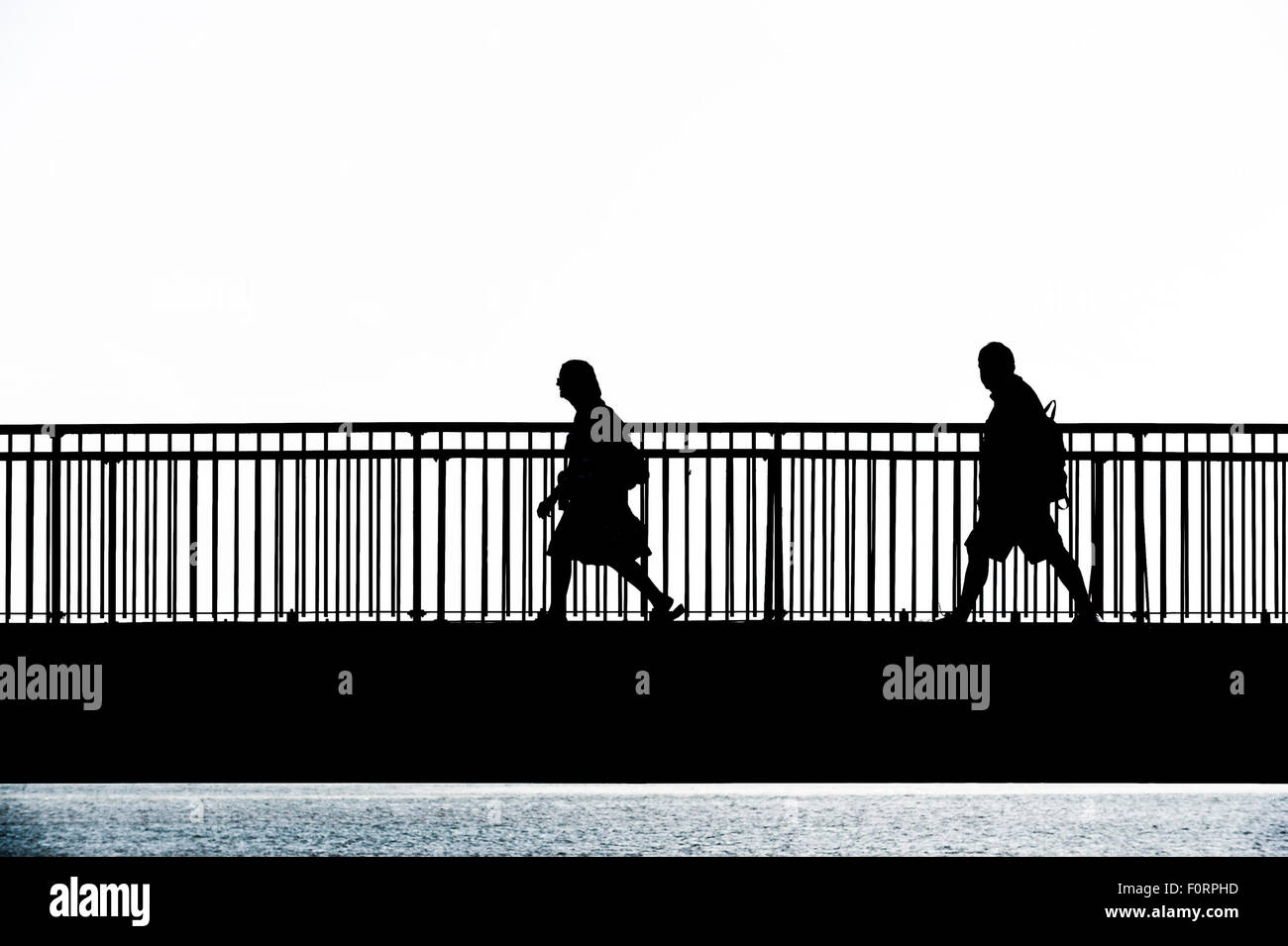 La silueta de la gente caminando a través de la brecha Louisa Puente en Broadstairs, Kent. Foto de stock