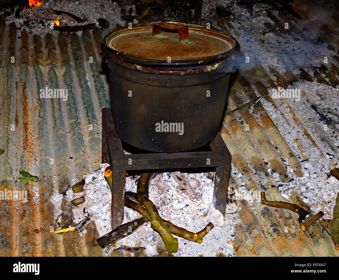 Caldero fuego cocinar vegetales con un gran caldero de hierro a través de la quema de leña Foto de stock