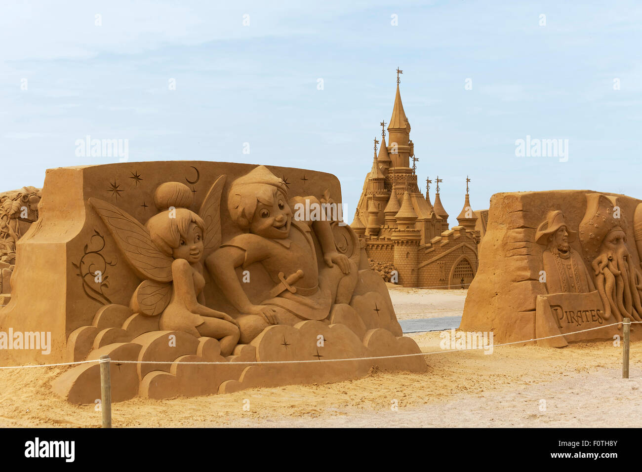 Peter Pan y elfos, dibujos animados de Walt Disney y el castillo de cuento de hadas de arena, escultura de arena festival sol de verano congelados, Oostende Foto de stock