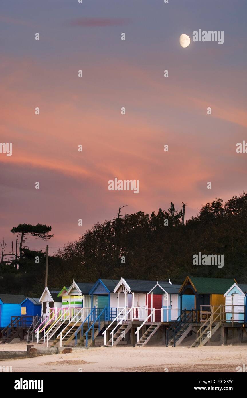 Fila de casetas de playa multicolor en moonlight, Norfolk, Inglaterra, Reino Unido Foto de stock