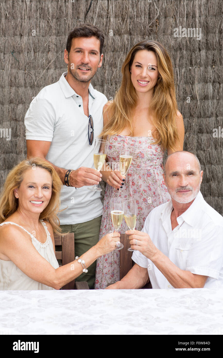 Dos padres con niños mayores hacer una foto de familia con champán Foto de stock