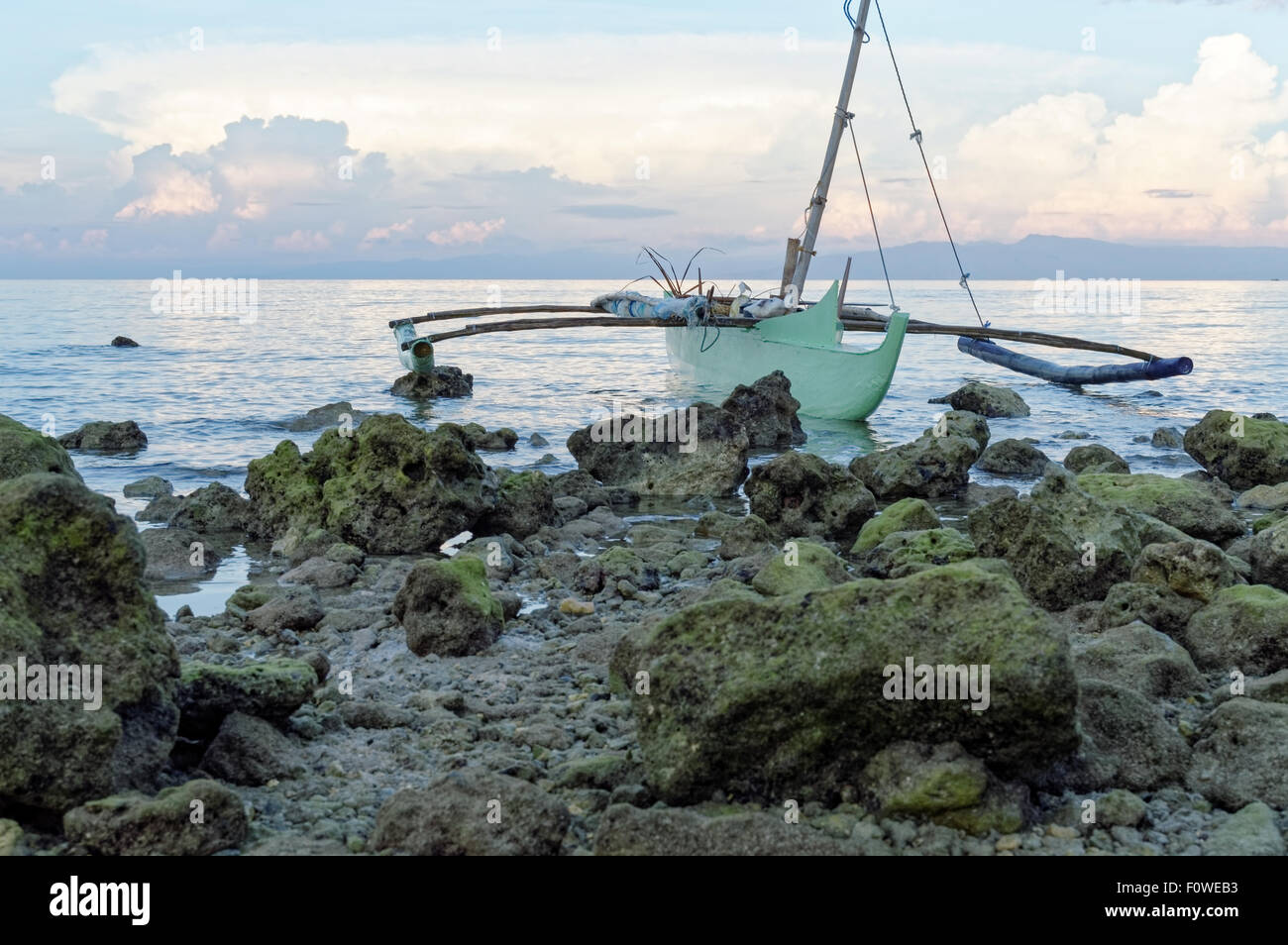 Vacía por un barco de pesca en las rocas. El pescador llegó a casa después de un viaje de pesca con capturas inadecuados y dejó su barco en el Foto de stock