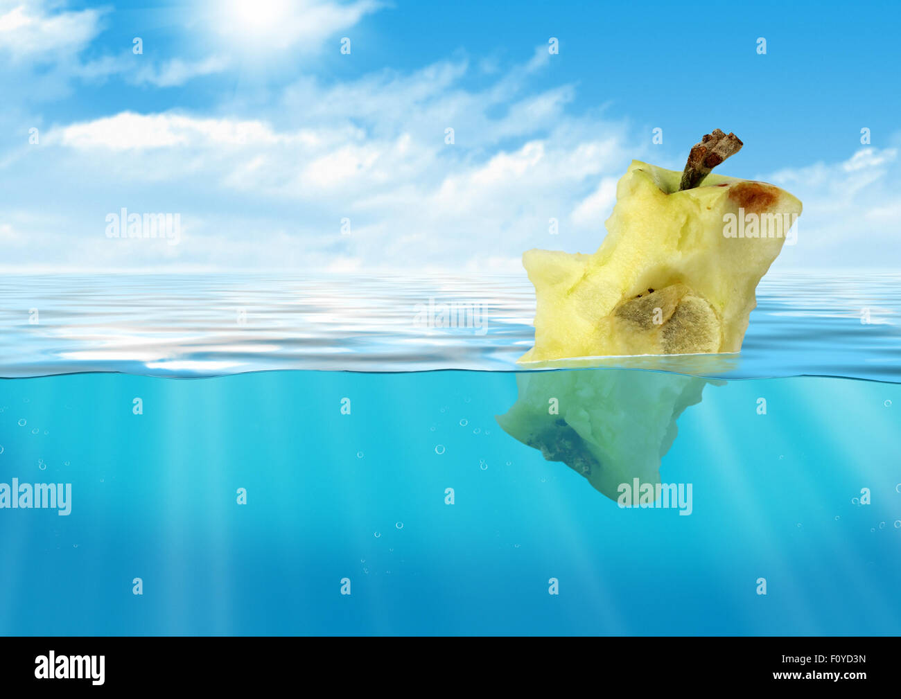 Manzana mordida flotando en el mar, la contaminación del depósito concepto Foto de stock