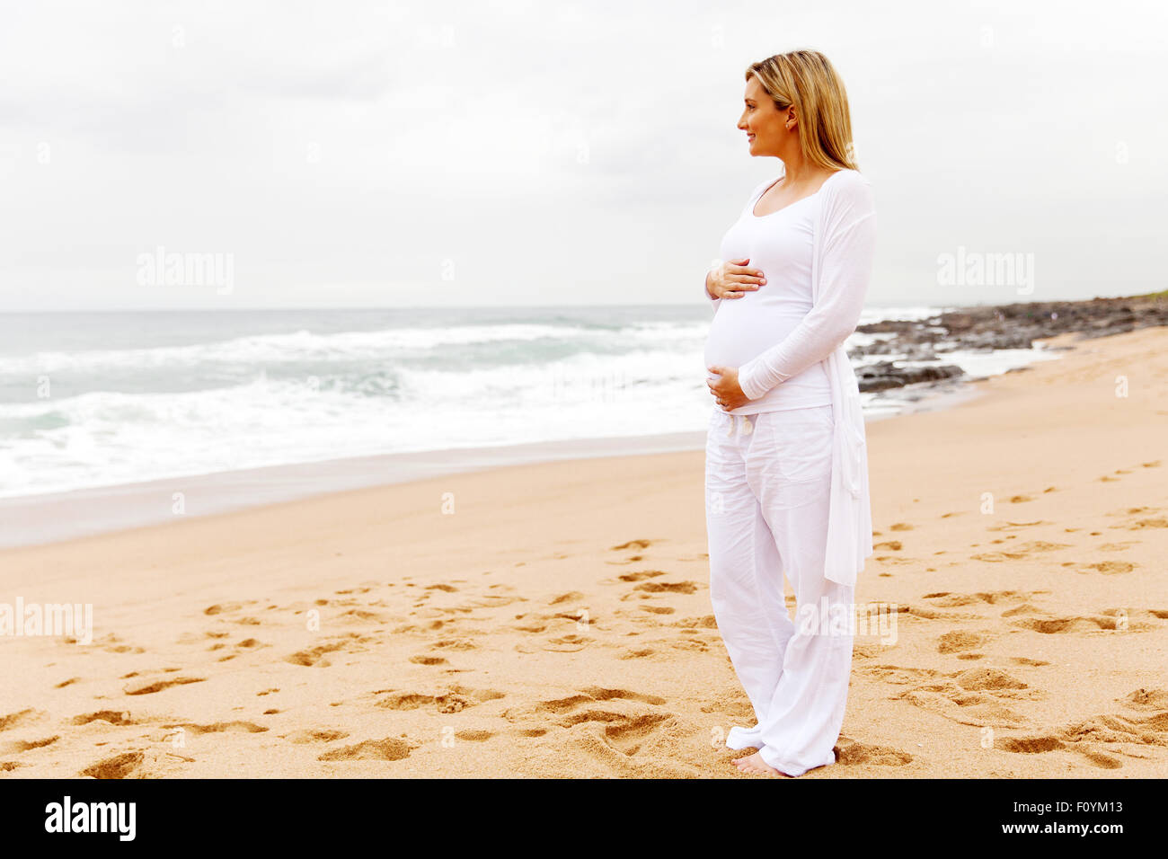 Mujer embarazada en ropa casual en la playa Fotografía de stock - Alamy
