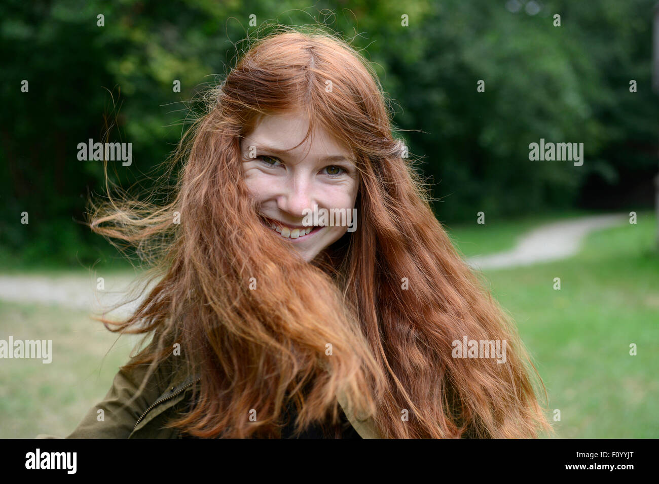 Adolescente con largo pelo rojo, moviendo su cabello, Alemania Foto de stock