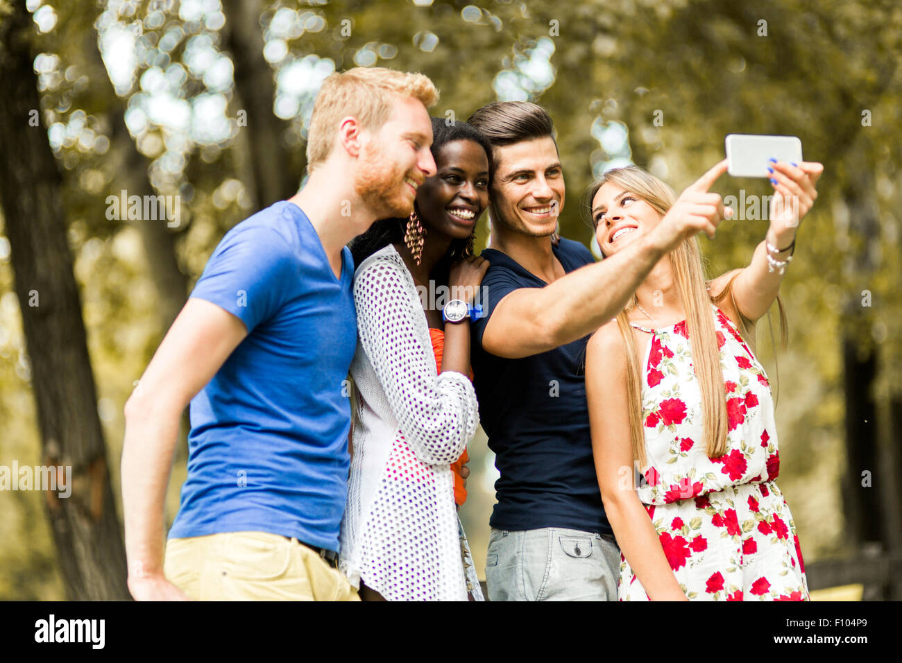 Grupo de jóvenes y parejas teniendo selfies en naturaleza y sonriente Foto de stock