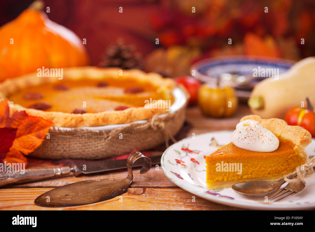 Pastel de calabaza casero sobre una mesa rústica con decoraciones de otoño. Foto de stock