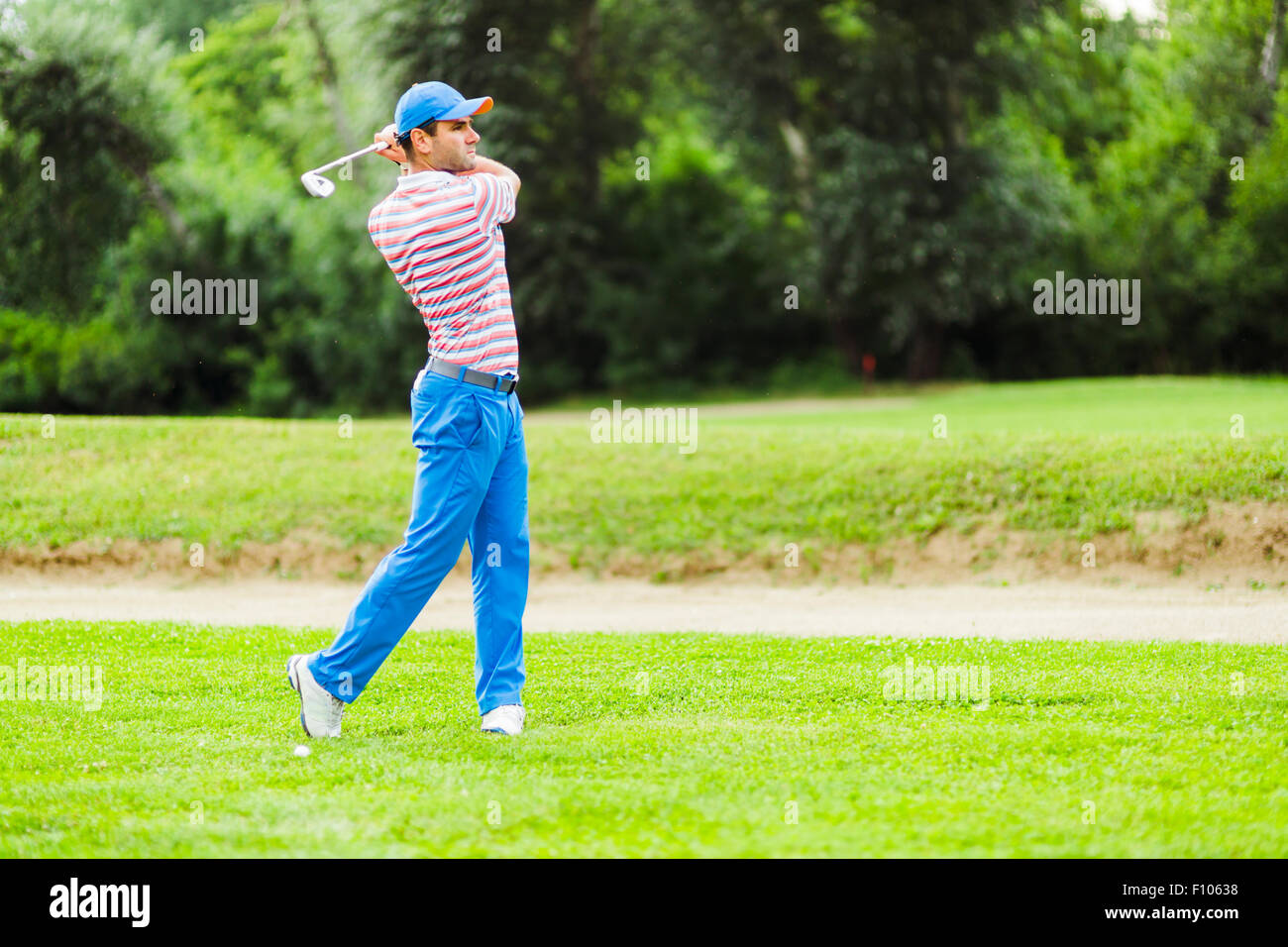 Golfista practicando y concentrar antes y después del disparo durante un día soleado Foto de stock