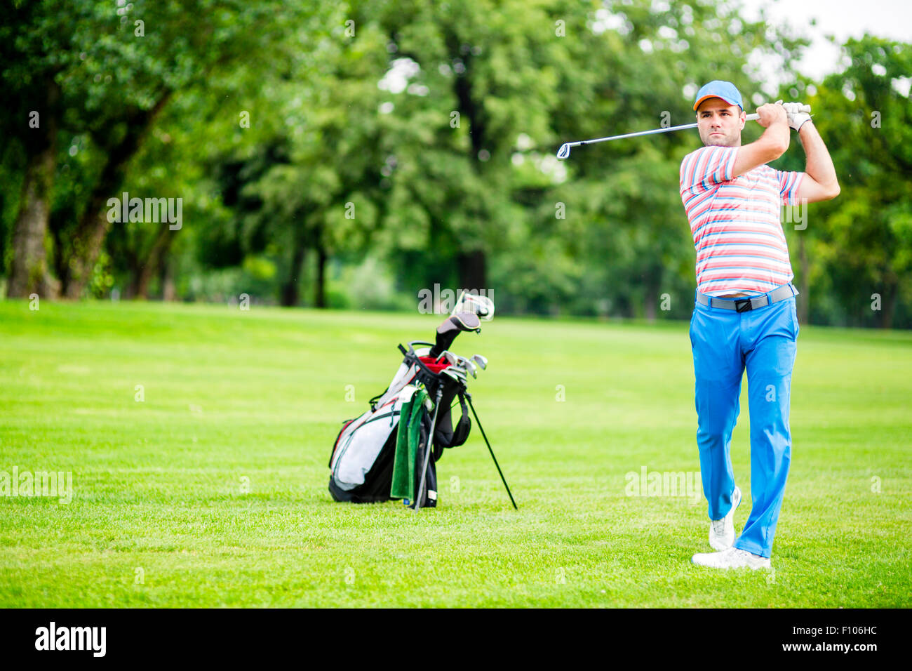 Golfista practicando y concentrar antes y después del disparo durante un día soleado Foto de stock