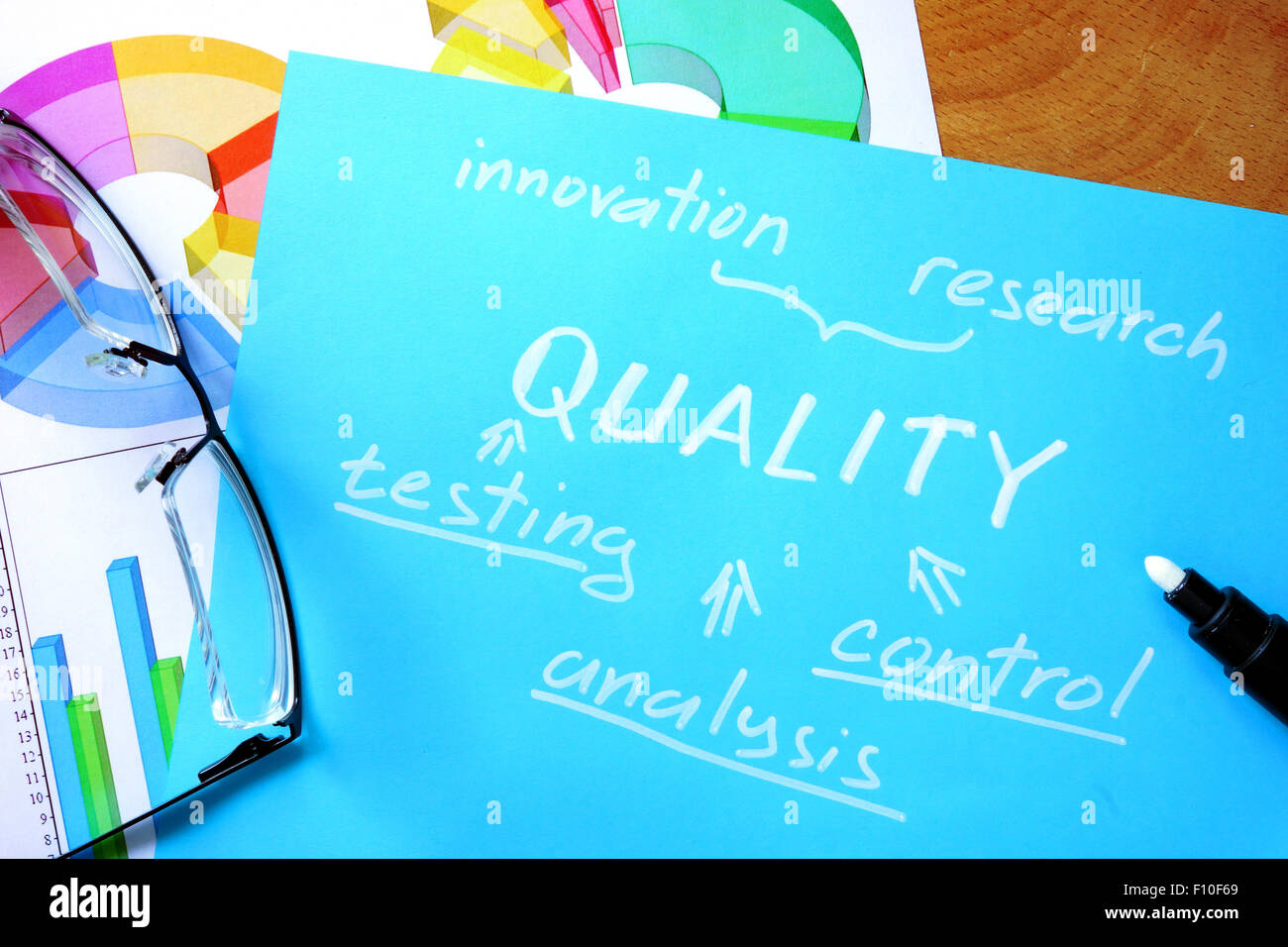 Papel azul con la palabra calidad y gafas. Foto de stock