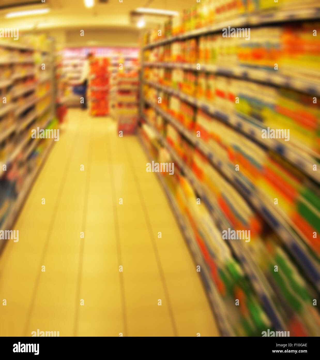 Desenfocado largos estantes de bienes y productos infantiles en el supermercado con el desenfoque de movimiento Foto de stock