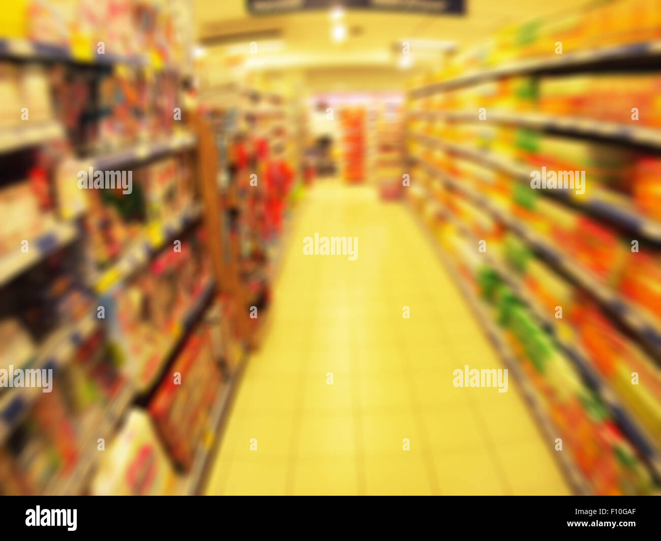 Desenfocado largos estantes de bienes y productos infantiles en el supermercado con el desenfoque de movimiento Foto de stock