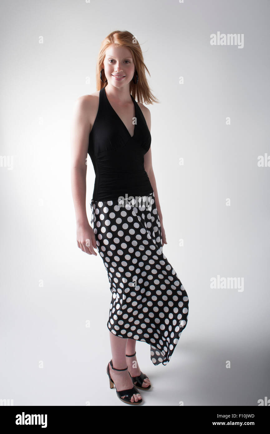 Elegante modelo posando en un top negro y falda larga negra con puntos  blancos Fotografía de stock - Alamy