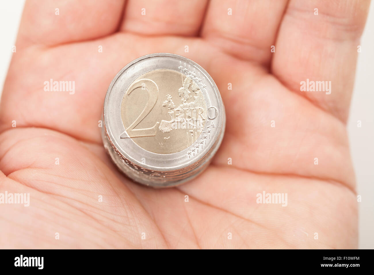 Dos monedas de euro en la mano Foto de stock