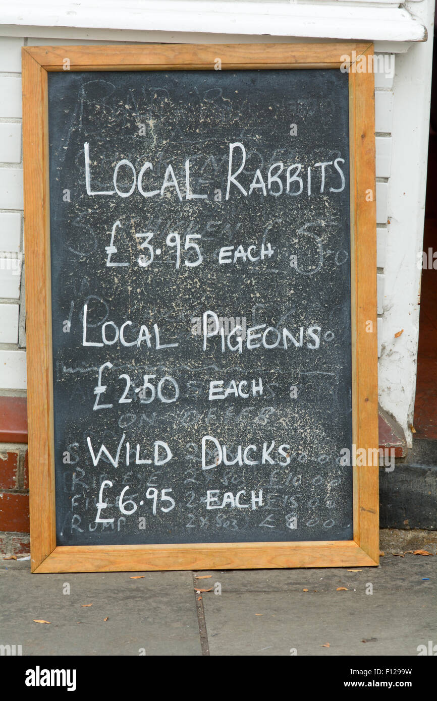 Los carniceros pizarra cartel con precios para los conejos, palomas y patos  en Totnes, Devon, Inglaterra Fotografía de stock - Alamy
