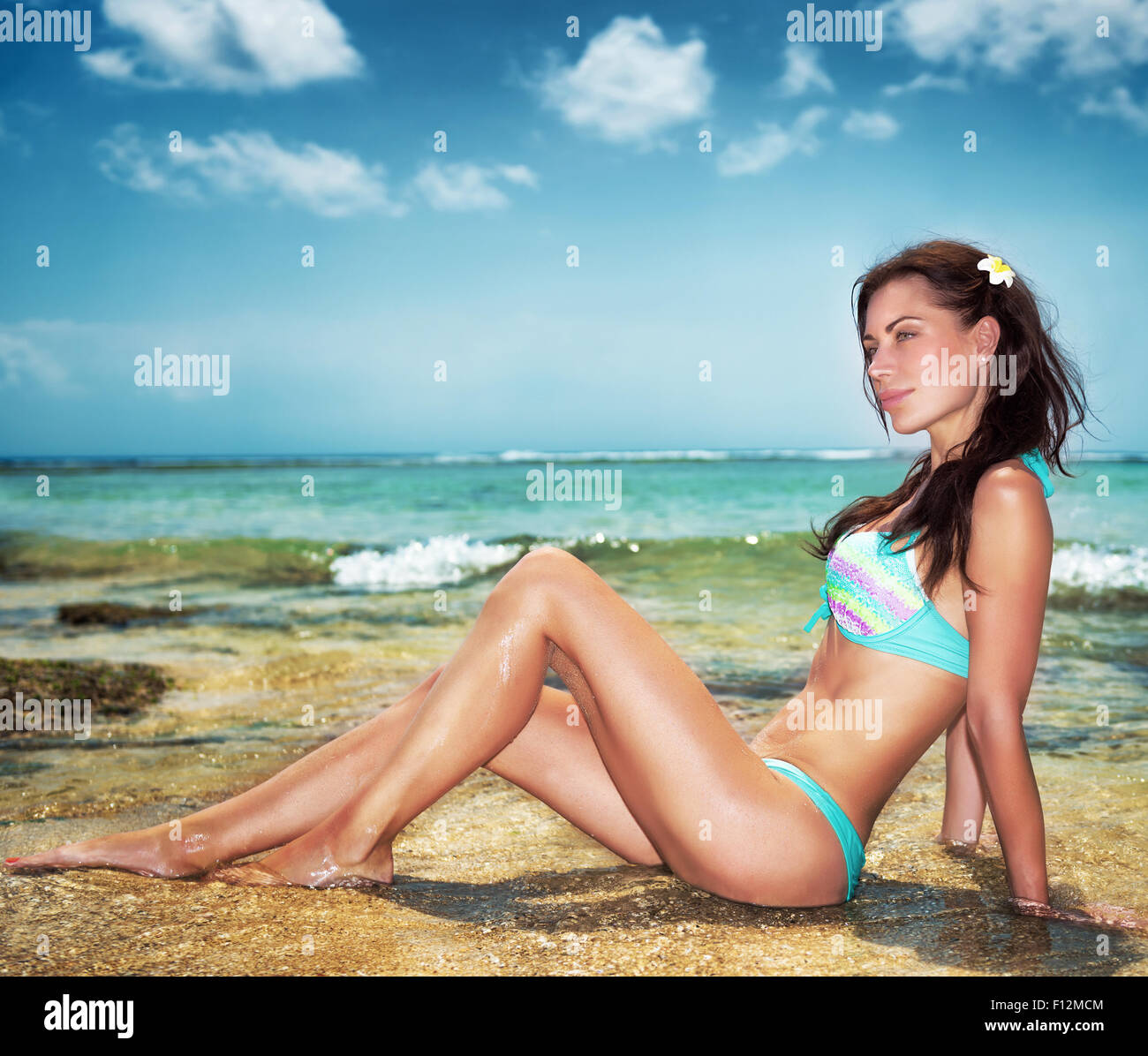 Mujer sexy en la playa, bella modelo sentada en la orilla y posar,  relajándose en el complejo tropical, disfrutando del verano de lujo  Fotografía de stock - Alamy