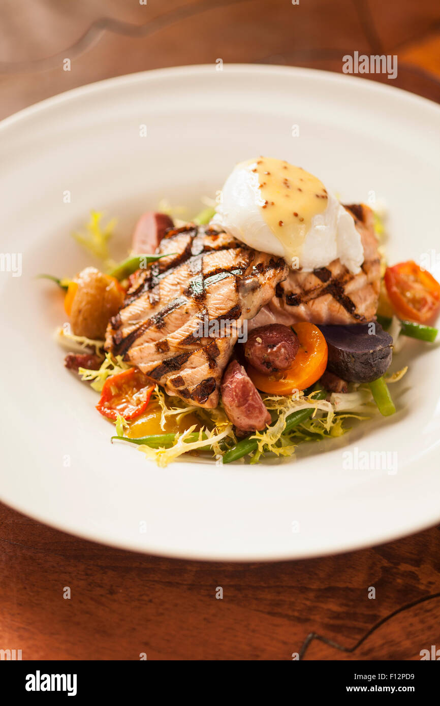 King Salmón a la parrilla con ensalada frisee, luppolino, huevo escalfado  suave y vinagreta de mostaza, el restaurante Bella Vista Fotografía de  stock - Alamy