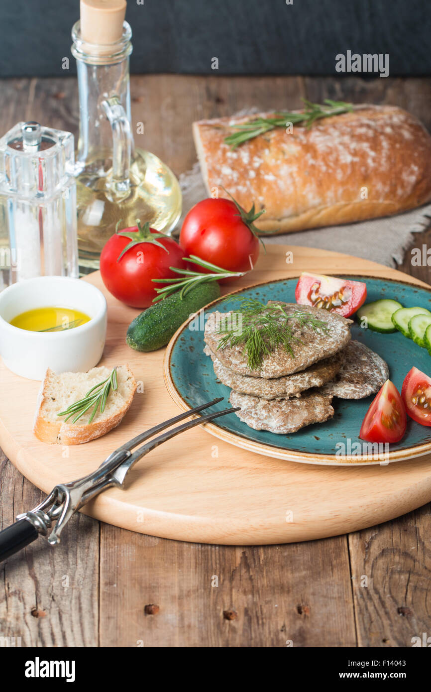 Empanadas de hígado con verduras, pan y aceite de oliva sobre fondo de