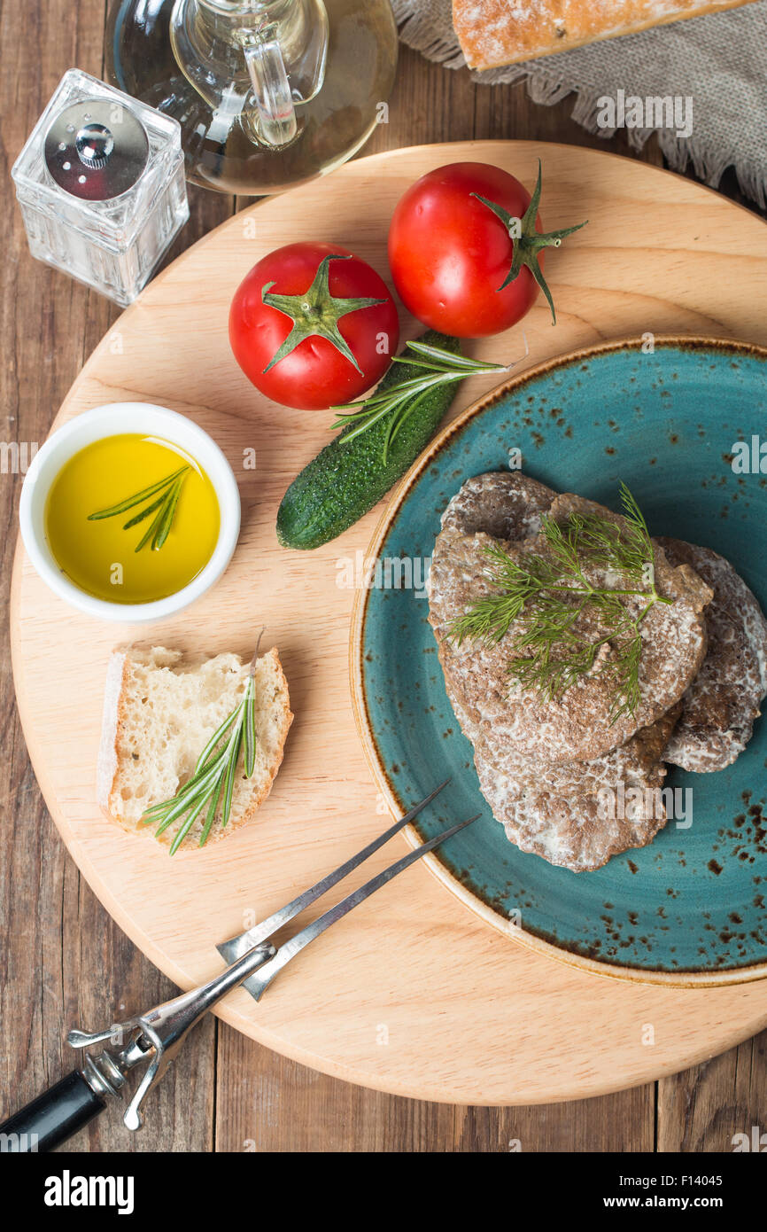 Empanadas de hígado con verduras, pan y aceite de oliva sobre fondo de