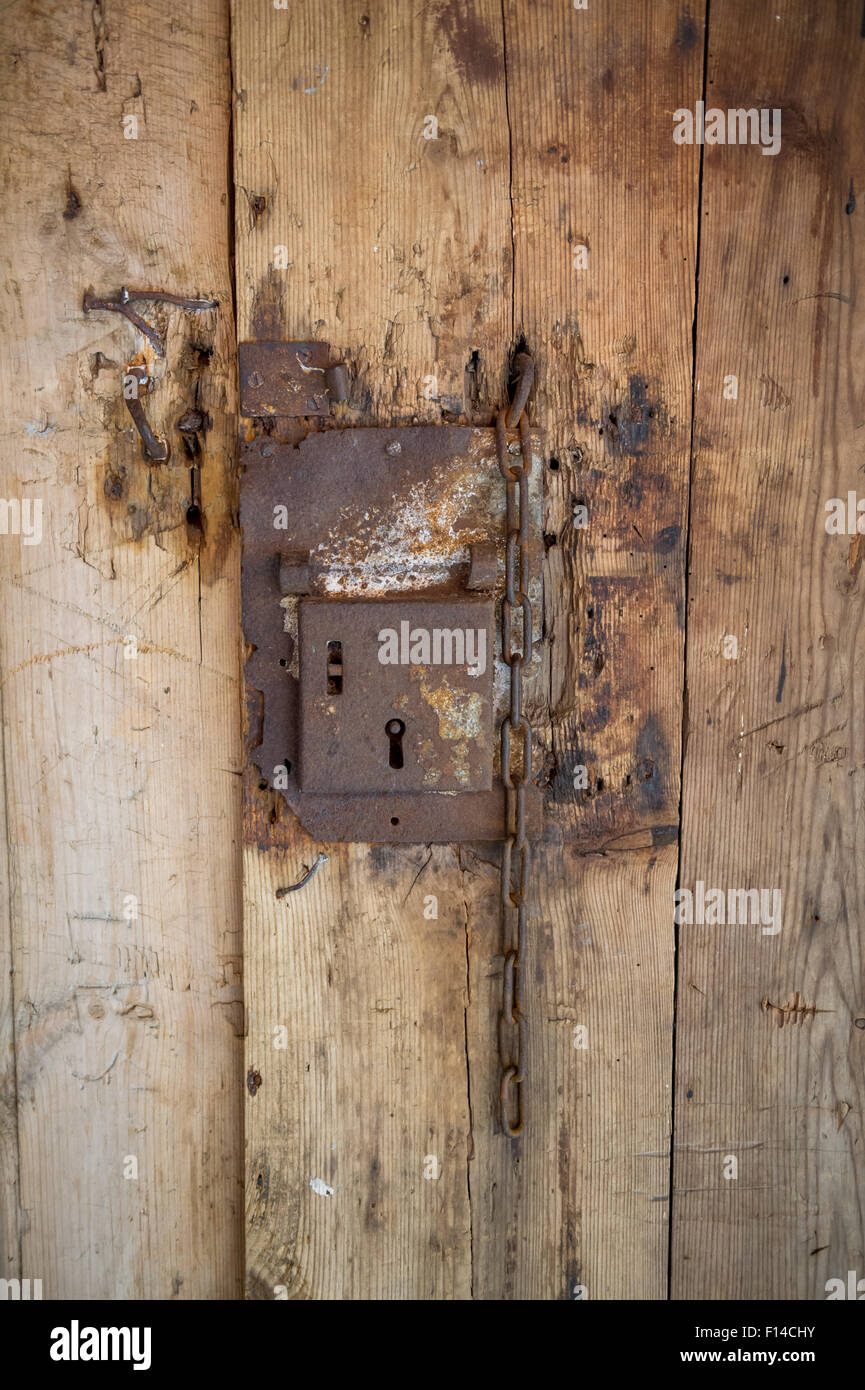 Cerradura de puerta oxidado viejo montado en una puerta de madera. Foto de stock