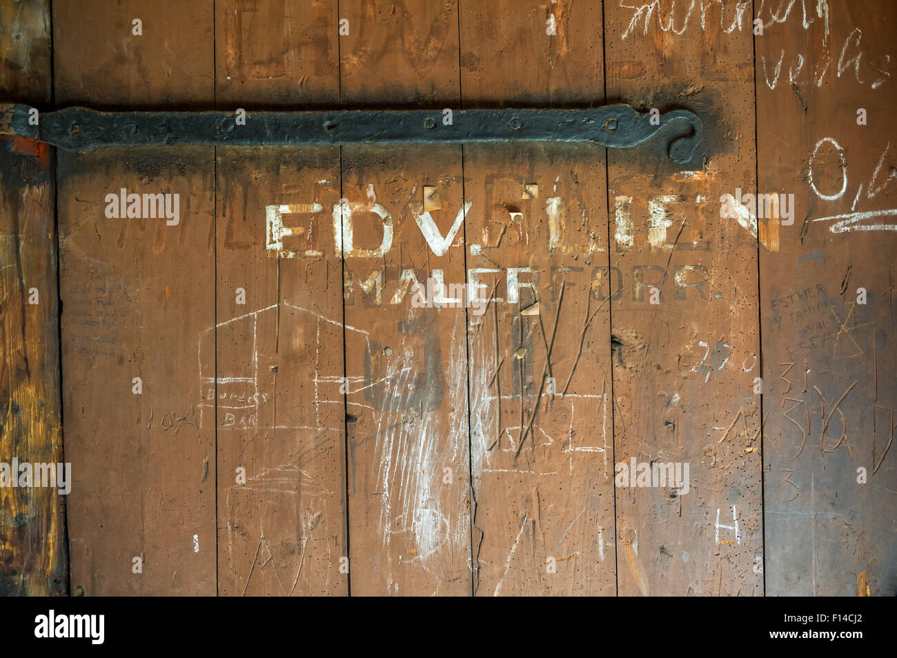Las bisagras de la puerta vieja oxidada montado en una puerta de madera. Foto de stock