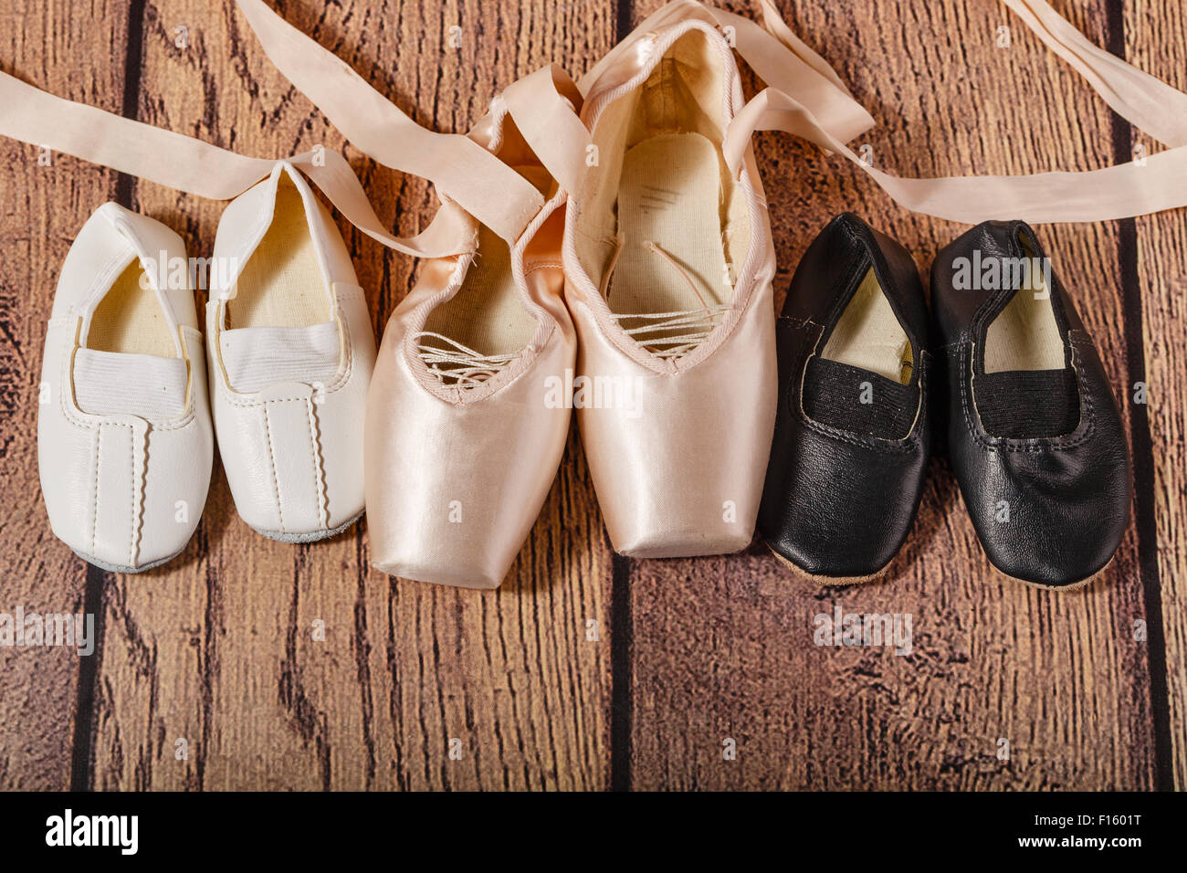 Ballet pointe zapatos y zapatillas de gimnasia para niños tumbarse en el  suelo de madera. El concepto de ballet clásico y danza moderna Fotografía  de stock - Alamy
