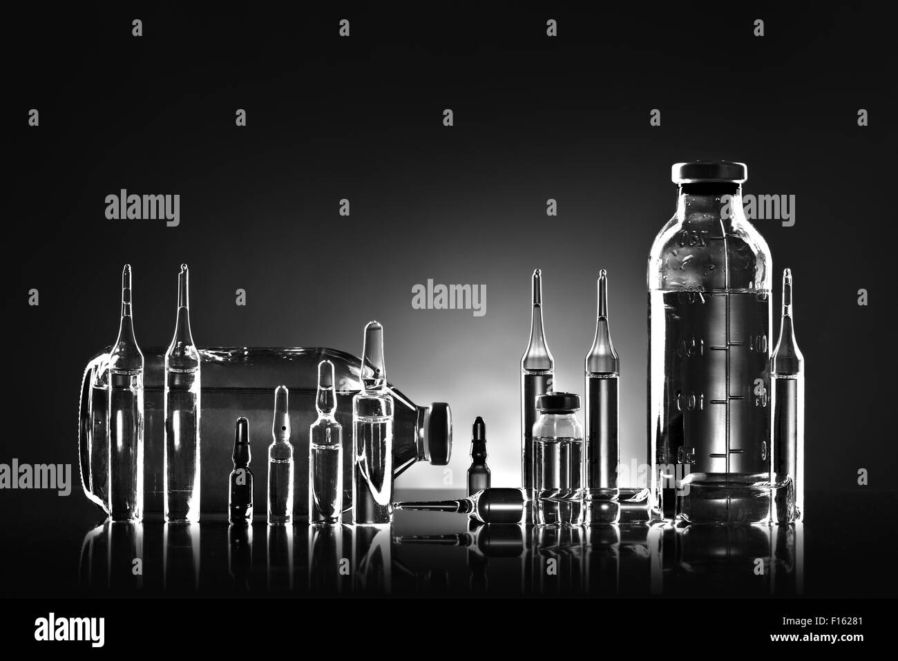 Grupo objeto de agente medicinal líquido en vidrio transparente, blanco y negro fotográfico horizontal Foto de stock