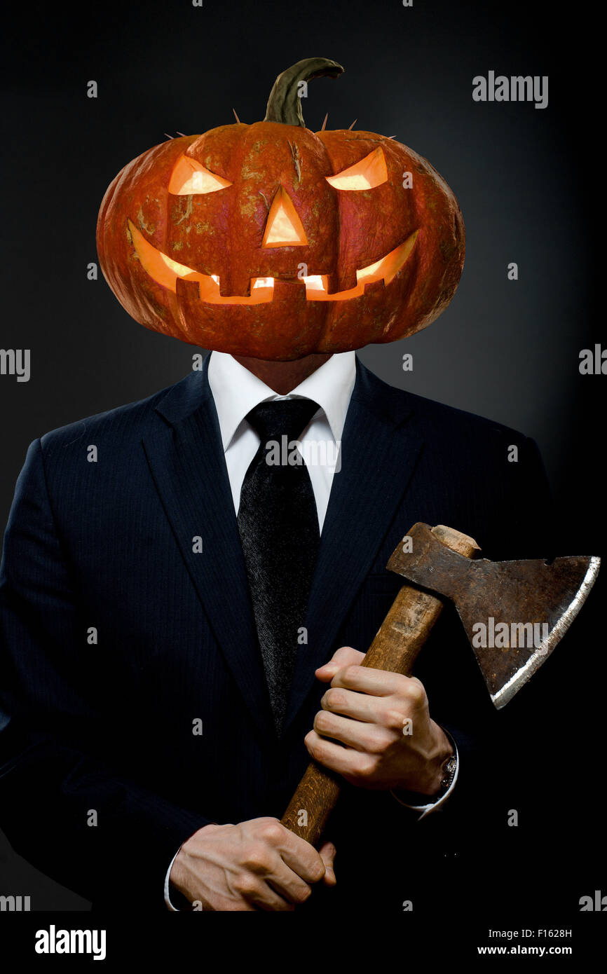 Hombre en traje negro con cabeza de calabaza con AX, concepto de Halloween  Fotografía de stock - Alamy