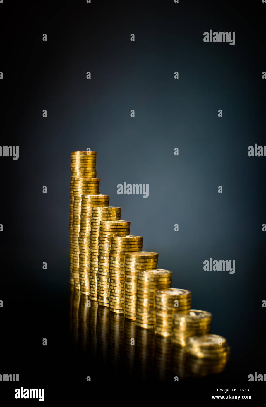 Muchas rouleau oro monetario o cambiar moneda, sobre fondo azul oscuro Foto de stock