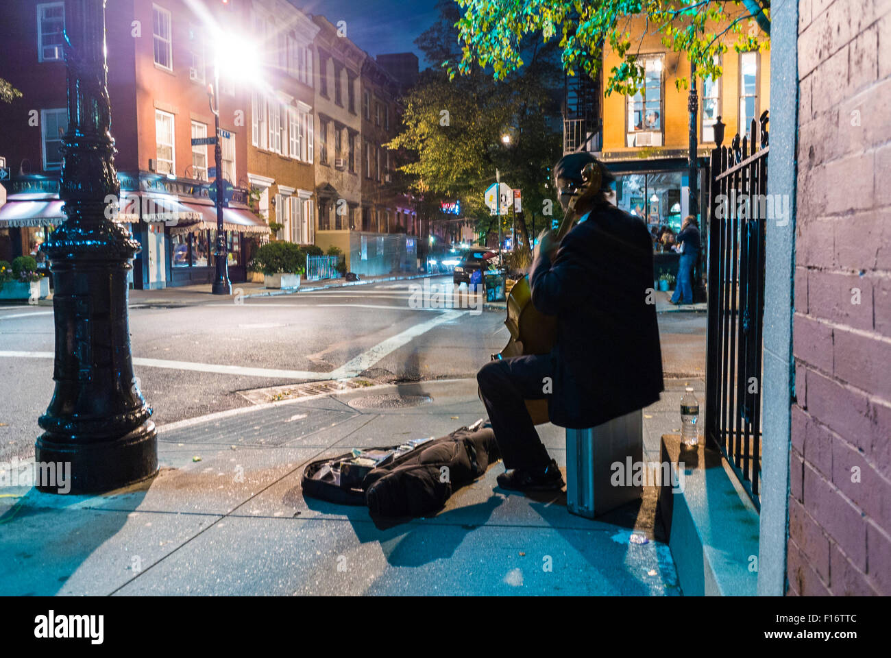 La Ciudad de Nueva York, EE.UU., escenas callejeras, viejo músico tocando la música clásica, en la esquina de la calle en Greenwich Village en la noche Foto de stock
