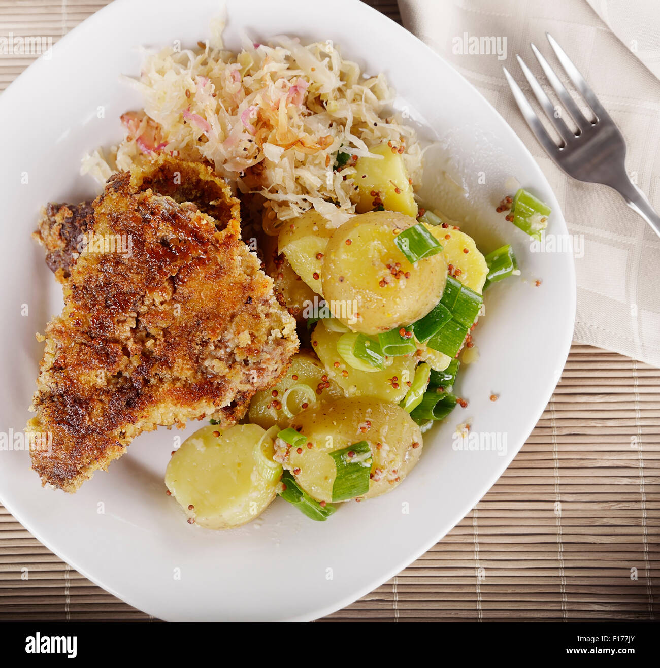 Schnitzel con ensalada de papas y chucrut,vista superior Foto de stock