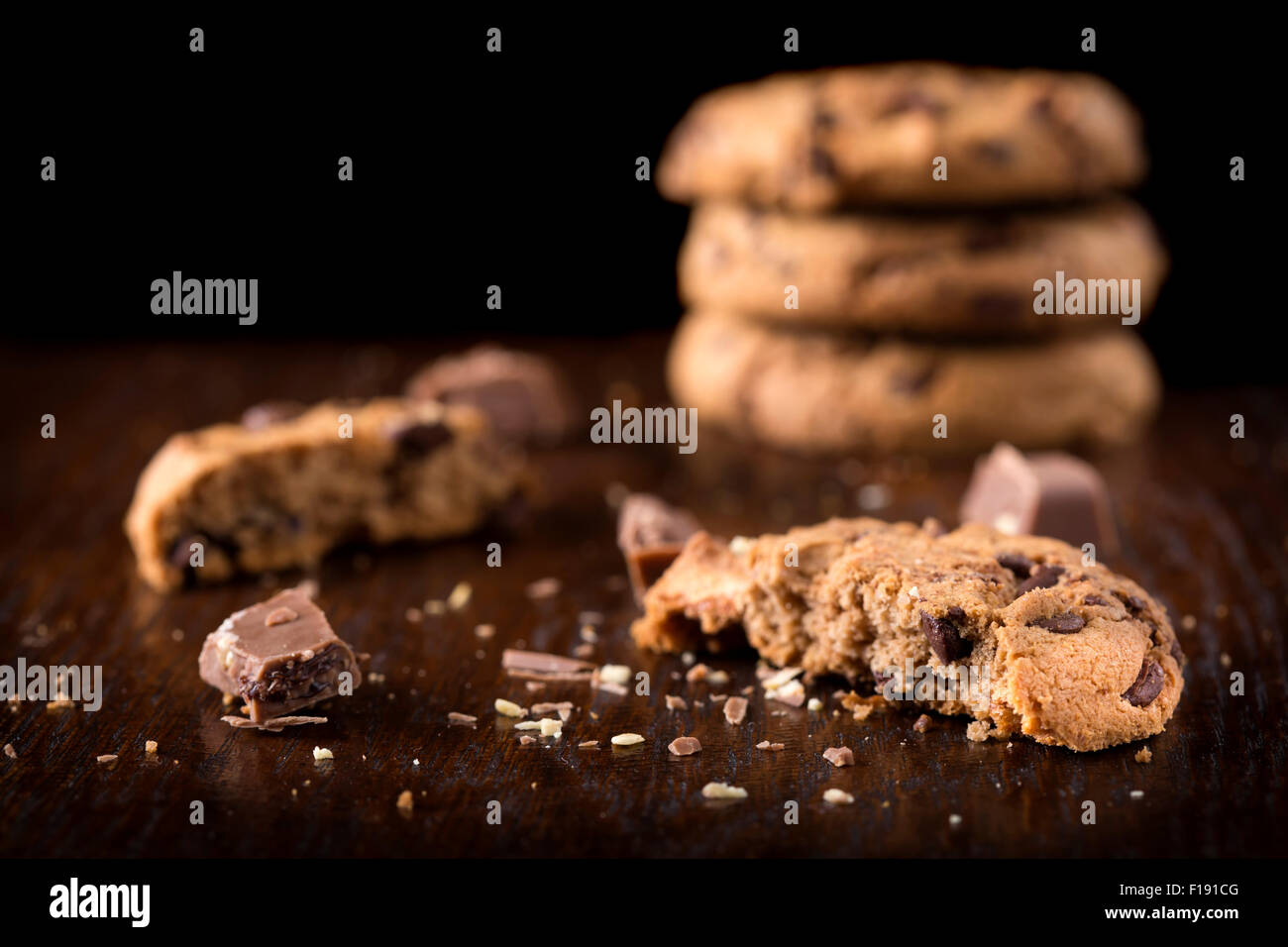 Las galletas con trocitos de chocolate y trozos de chocolate sobre fondo de madera Foto de stock