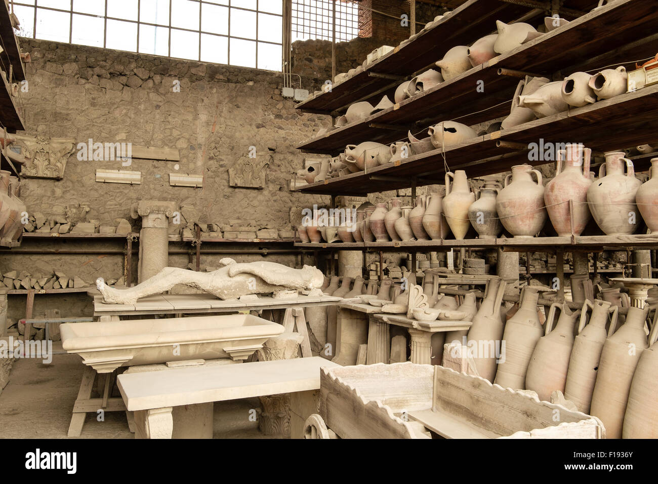 Ollas y otros artefactos de Pompeya en el almacenamiento y en la pantalla en la estantería Foto de stock
