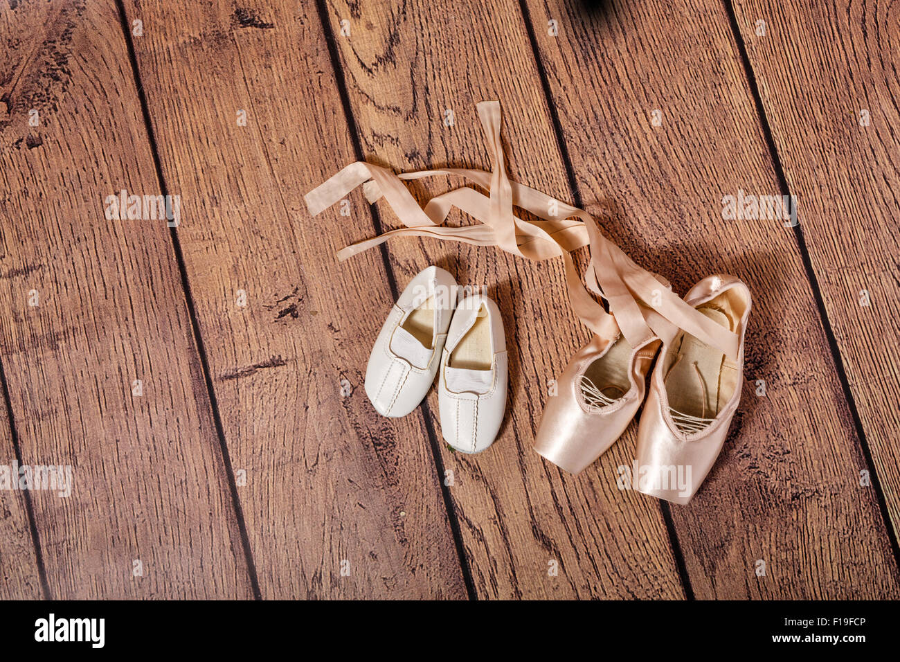 Ballet pointe zapatos y zapatillas de gimnasia blancas yacen en el suelo de  madera. El concepto de ballet clásico y danza moderna Fotografía de stock -  Alamy