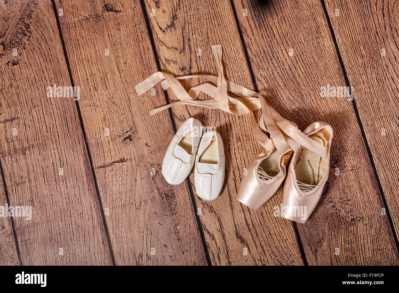 Ballet pointe zapatos y zapatillas de gimnasia blancas yacen en el
