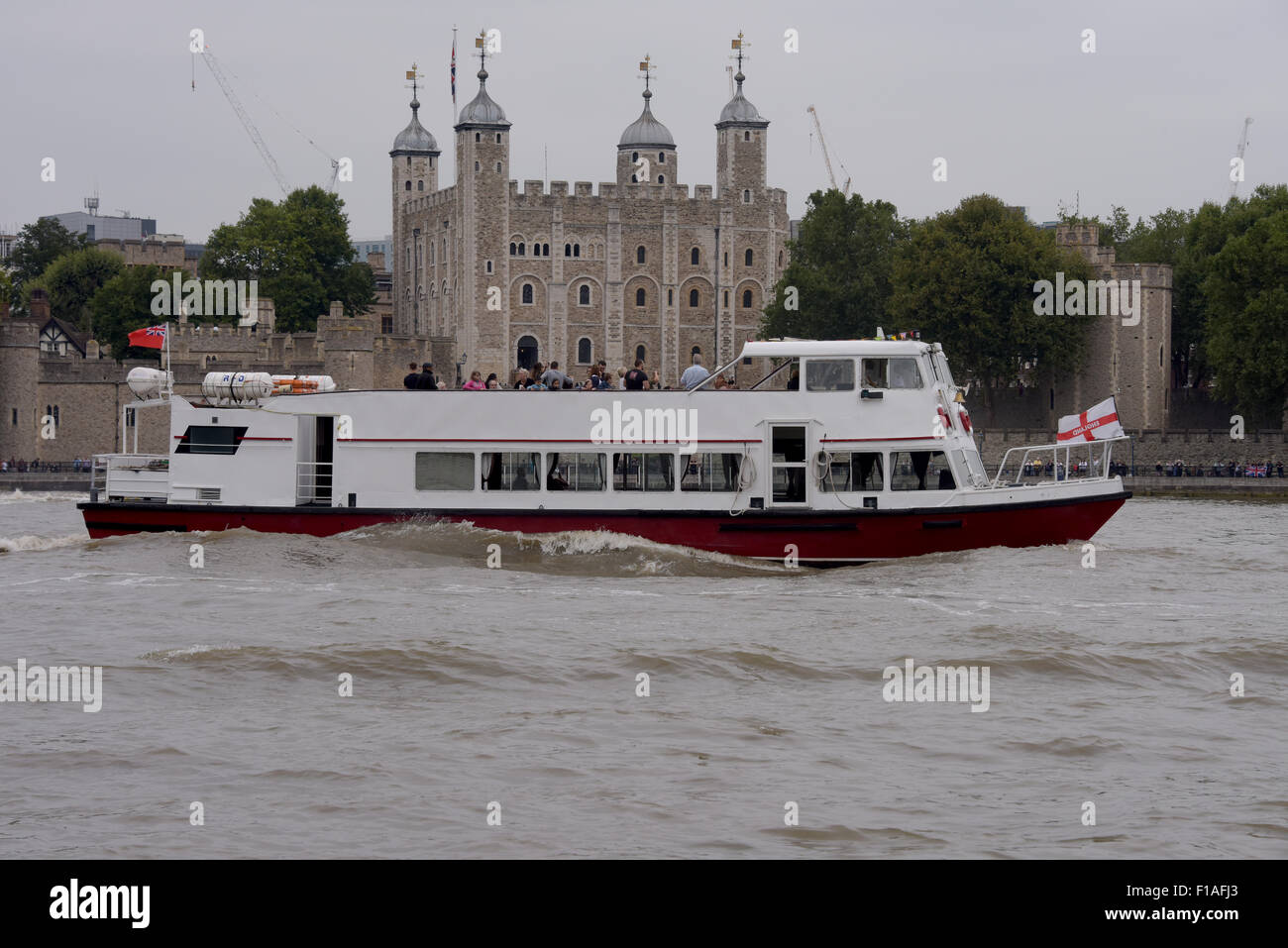 Los barcos turísticos sobre el río Támesis en Londres, pasando por la Torre de Londres, Inglaterra Foto de stock