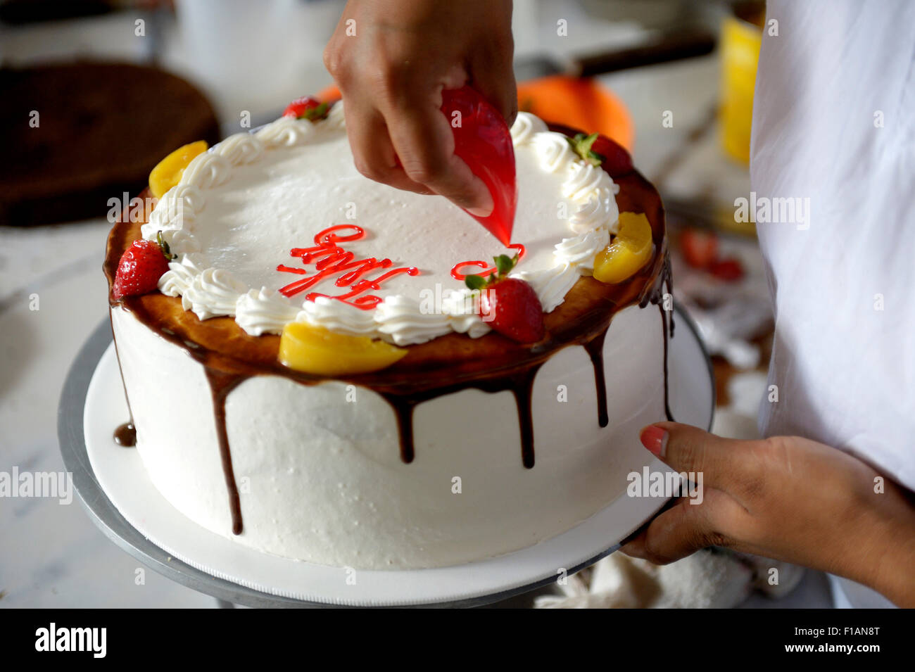 Pastelero decorar tarta de crema, cerrar Fotografía de stock - Alamy