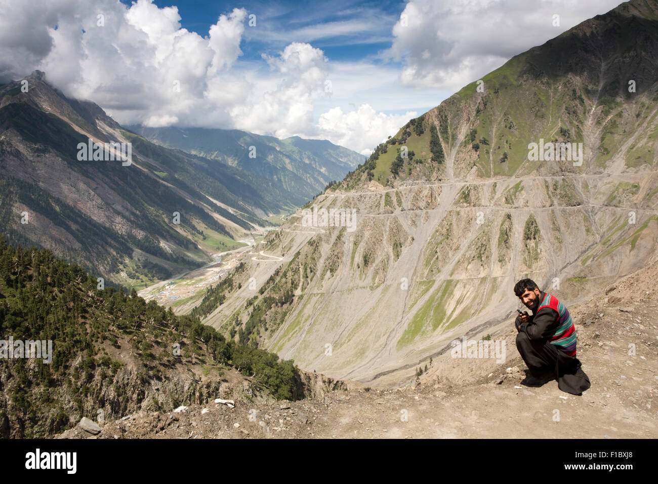 India, Jammu & Kashmir, Srinagar a Leh autopista, hombre local de teléfono móvil junto a carretera Zojila trepar a pasar Foto de stock