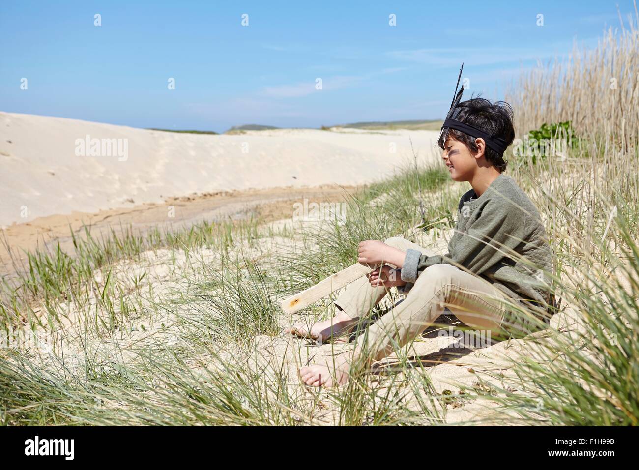 Joven, vistiendo disfraces, sentados en las dunas de arena Foto de stock