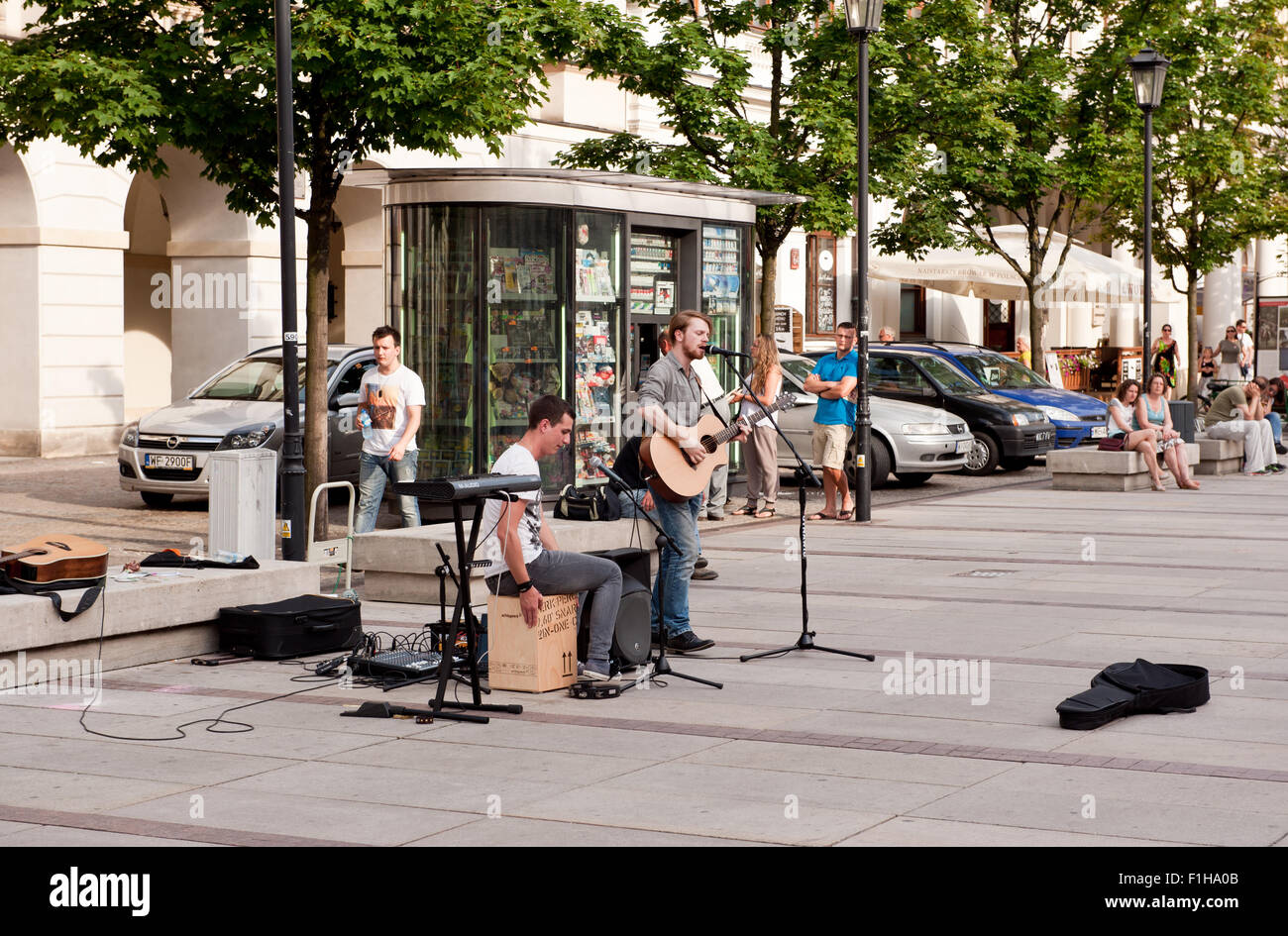 Dos hombres música street performance, cantando y tocando la guitarra en la Ciudad Vieja de paseo en Varsovia, Polonia. Los hombres jóvenes espectáculo para los turistas Foto de stock