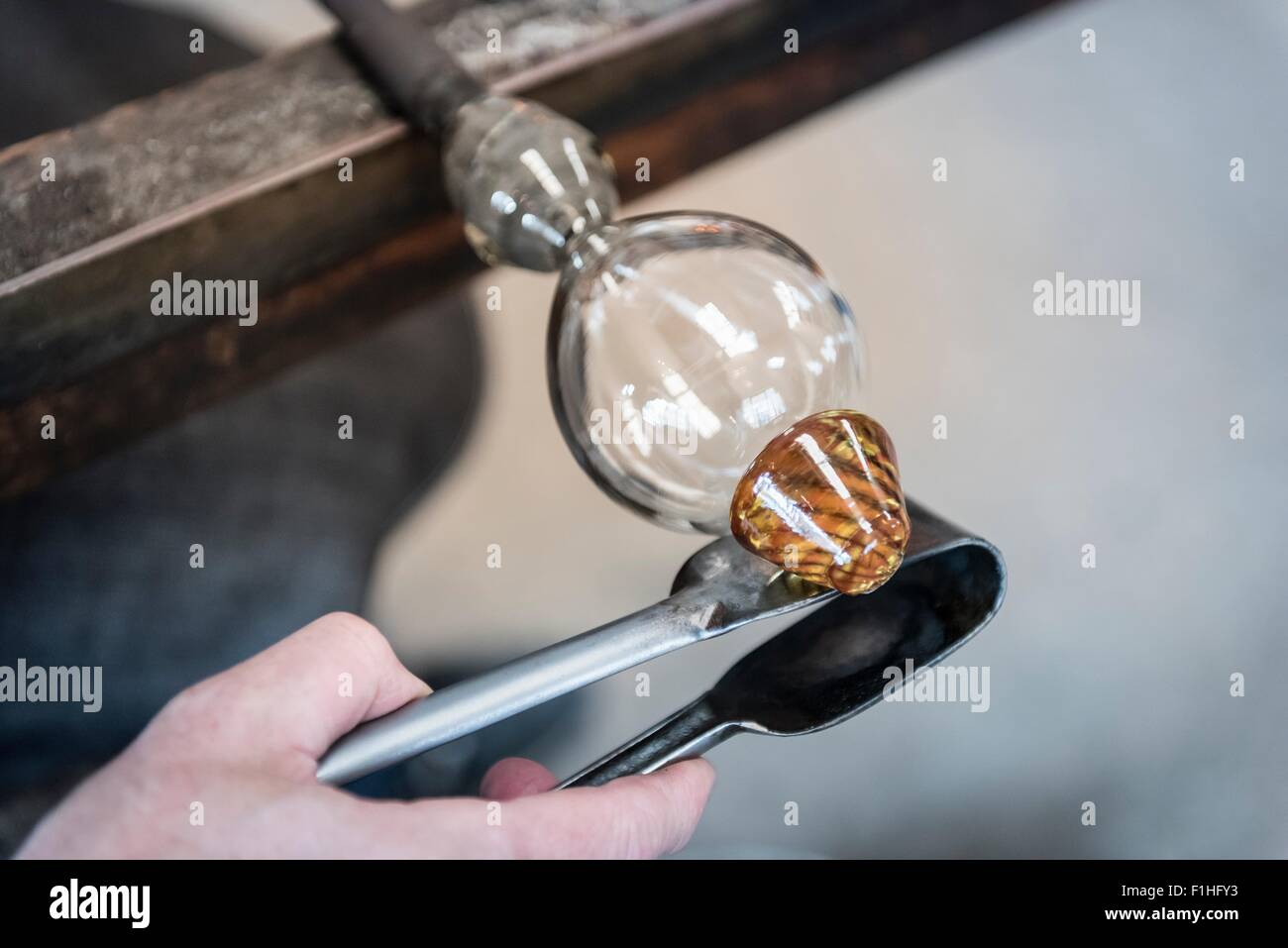 Agregar Glassblower tallo de vidrio fundido al vidrio Foto de stock