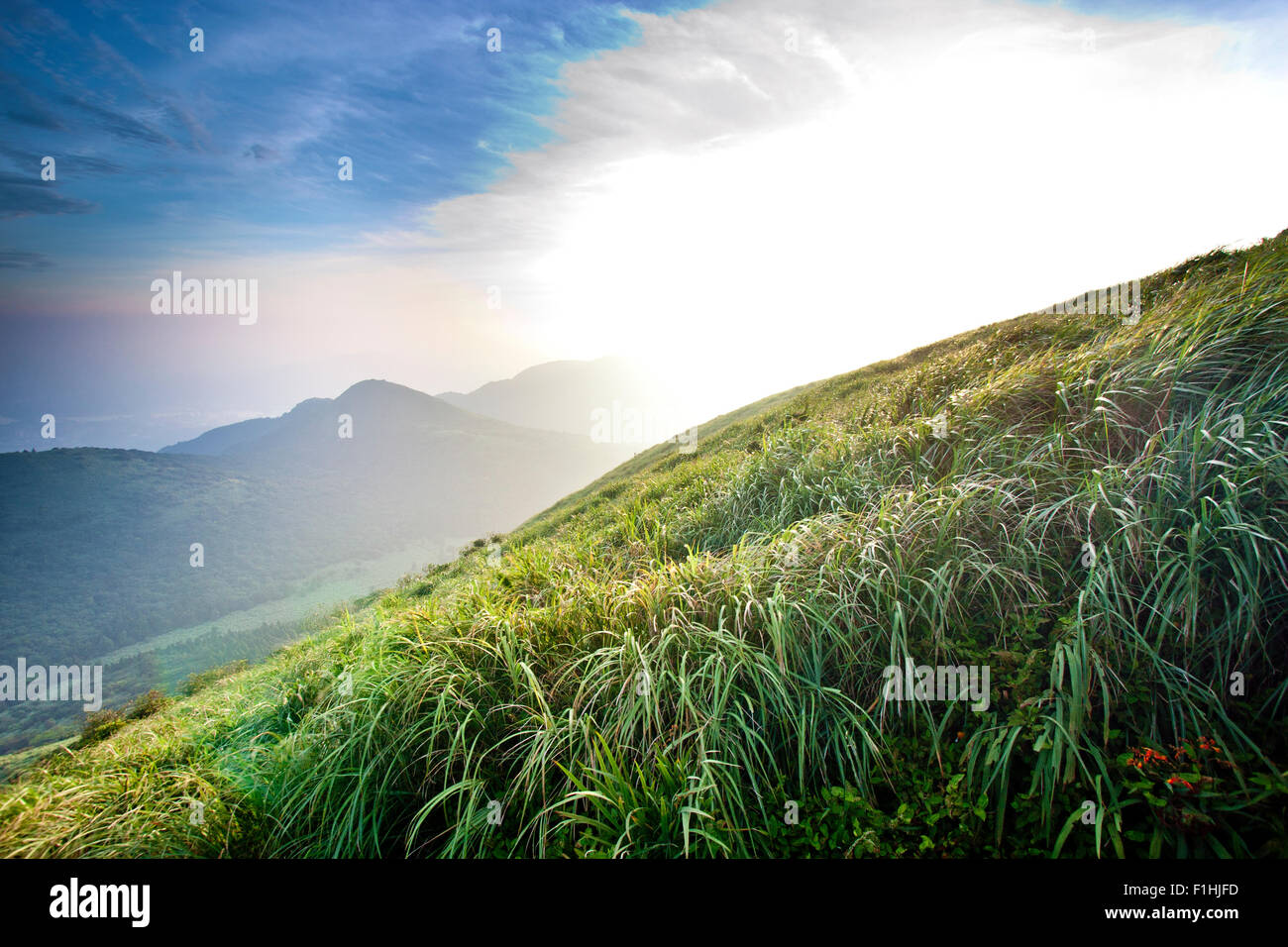 Hermoso paisaje de montañas con sun contra el azul cielo nublado Foto de stock