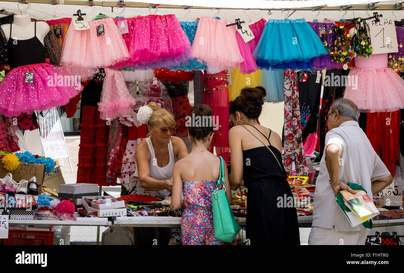 Un puesto en el mercado en Puerto Banus, Marbella, España, venta de niños coloridos vestidos de tamaño Foto de stock