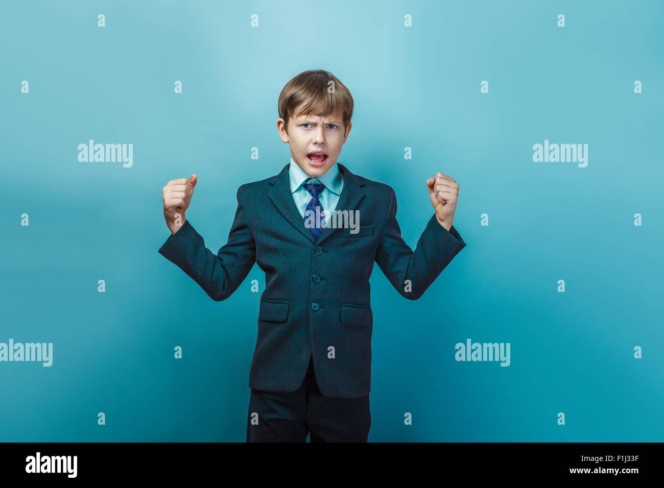 Un muchacho de doce en un traje de apariencia europea gritando enojado en Foto de stock