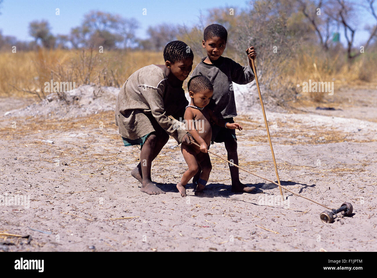 Bushman niños jugando con el juguete afuera, Namibia, África Foto de stock