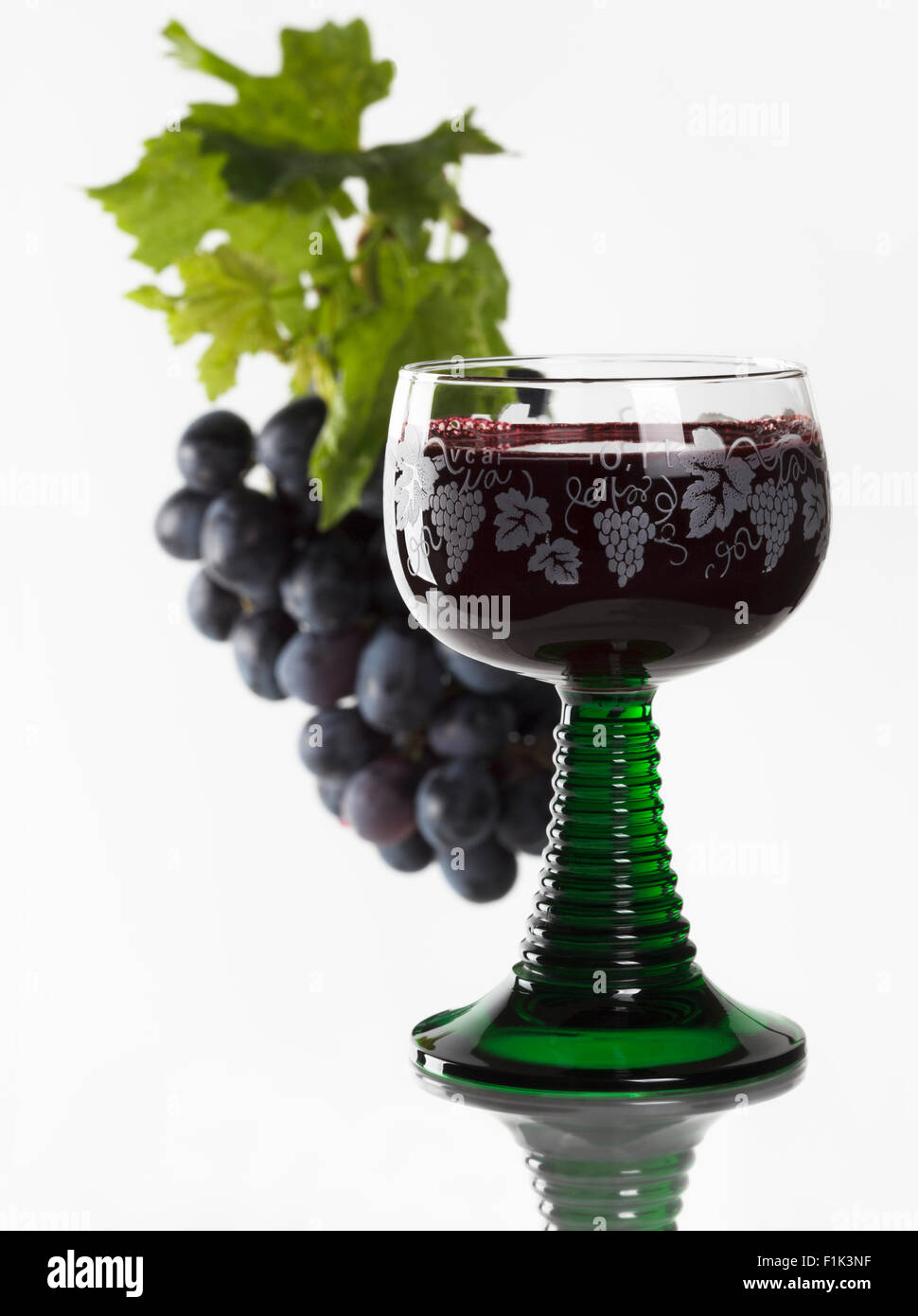 Copa de vino tinto y las uvas rojas frescas Foto de stock